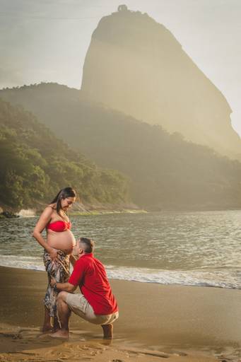 marido beijando a barriga da esposa grávida na Urca, Praia Vermelha / Rio de Janeiro.