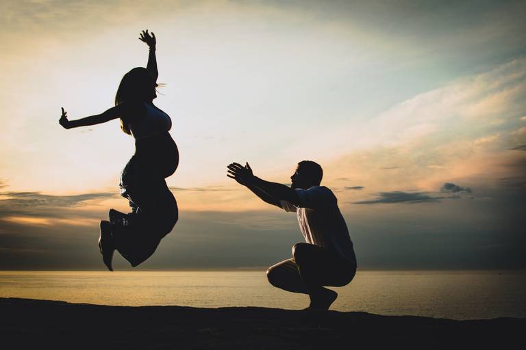 Gestante pulando na praia de grumari.