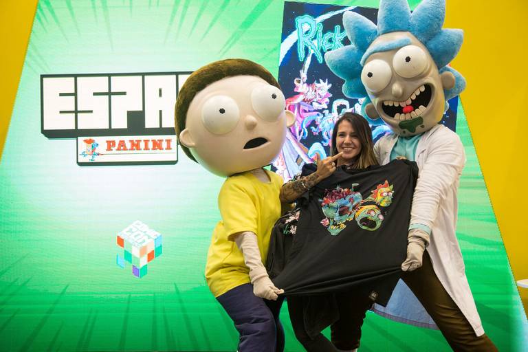 Personagens de desenho interagindo e tirando foto com um fã em uma feira, criando um momento divertido.