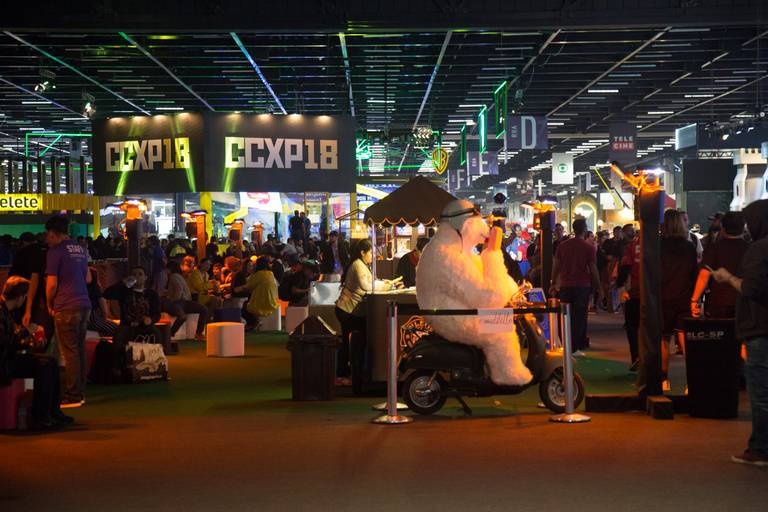 Vista geral de uma feira movimentada, com estandes, expositores e grande circulação de visitantes.