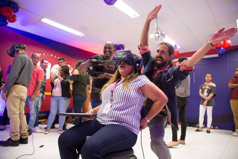 Pessoa interagindo com uma experiência de realidade aumentada em um evento, com óculos ou dispositivo em uso.