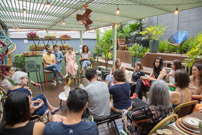 Roda de participantes em um evento, com foco nas expressões e na comunicação entre as pessoas.