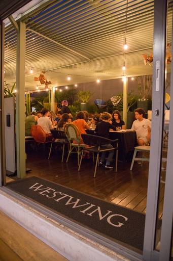 Mesa arrumada para o workshop, com materiais artísticos individuais prontos para os participantes iniciarem a atividade.