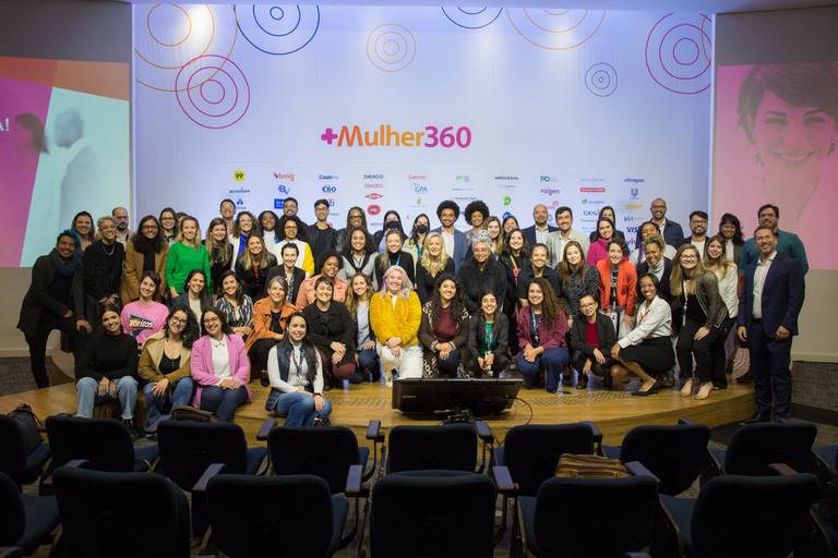Grupo de participantes posando para foto no palco, em um momento de reconhecimento ou celebração.