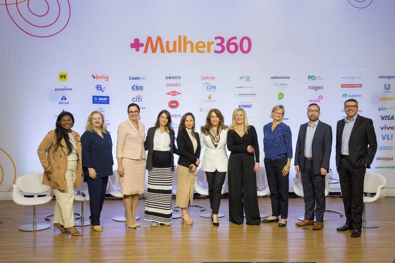 Palestrantes posando para foto com um fundo temático ou cenário do evento, realçando o ambiente.