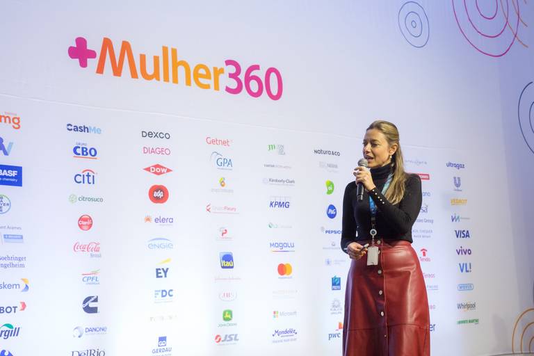 Palestrante com olhar direcionado à plateia, demonstrando conexão e engajamento com o público.