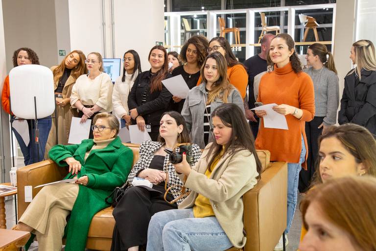 Público atento e engajado em um workshop, com foco nas expressões de aprendizado e participação.