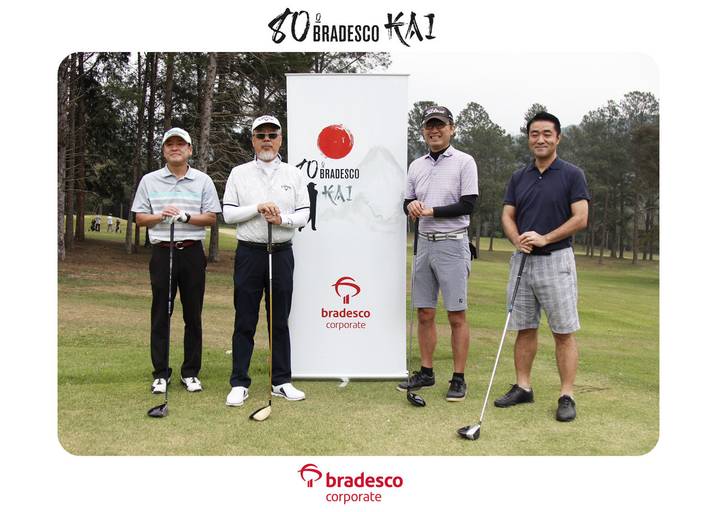Quatro jogadores de golfe posando juntos no campo, com seus tacos e equipamentos, em um momento de descontração