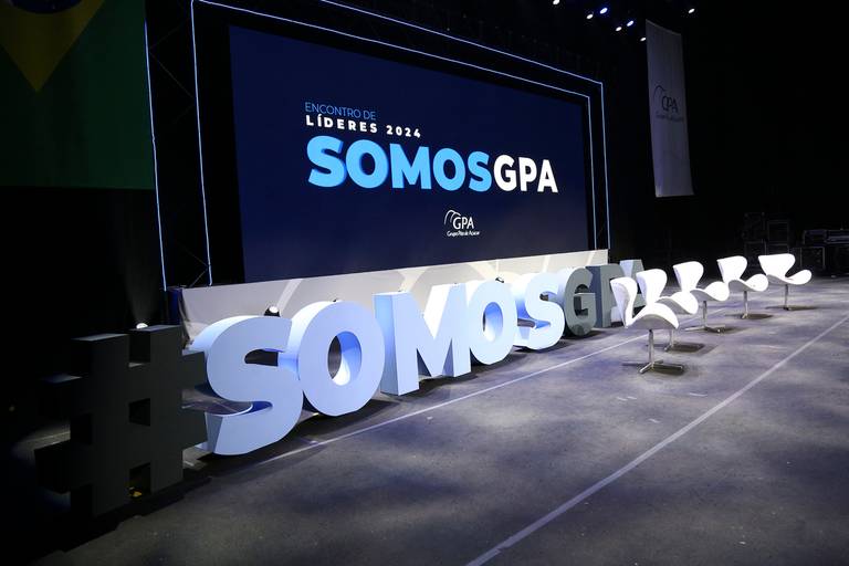 Letreiros luminosos ou banners do evento, exibindo o nome ou tema da celebração.