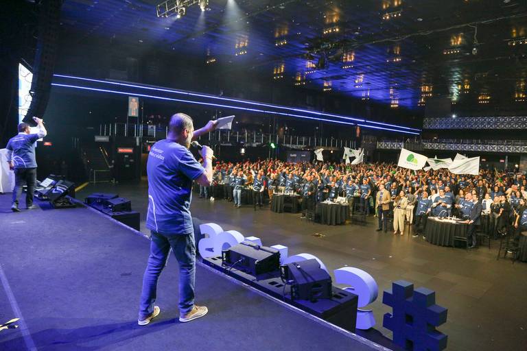 Palestrantes interagindo com o público, possivelmente respondendo a perguntas ou fazendo provocações, em um diálogo ativo.