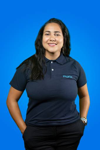 Retrato empresarial de uma mulher, com postura ereta e presença marcante em fundo azul.