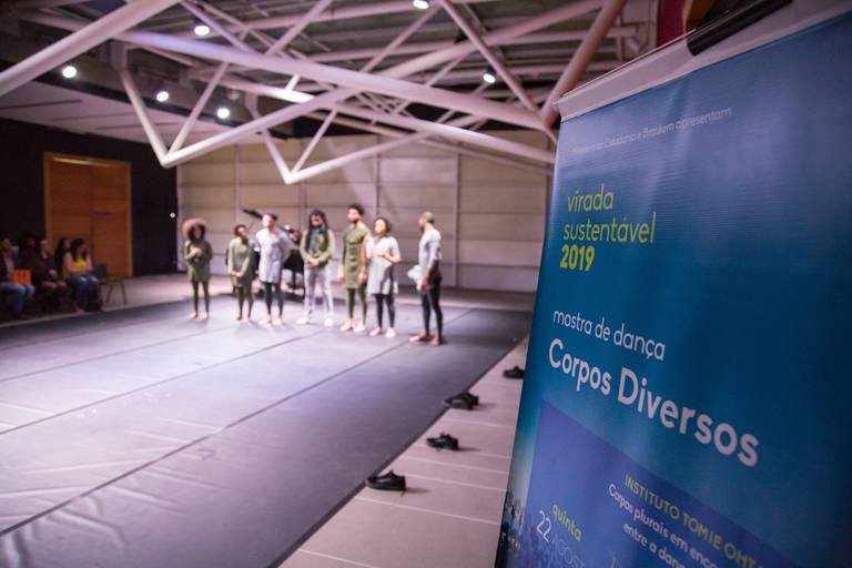 Banner de divulgação de um evento cultural, com dançarinos em segundo plano, indicando o tema da celebração.