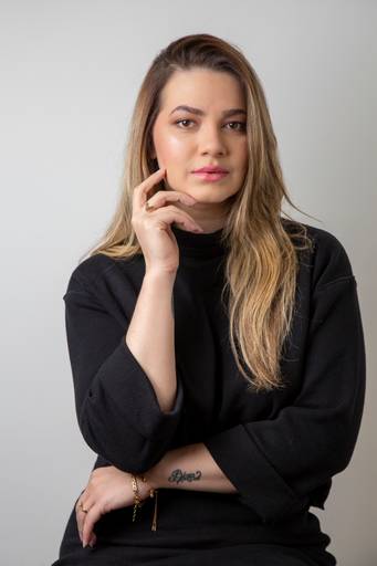 Retrato profissional sério de Mulher, com a mão levemente apoiada no rosto, transmitindo foco e seriedade. (Retrato Corporativo, São Paulo, Fotógrafo Bruno Arita)