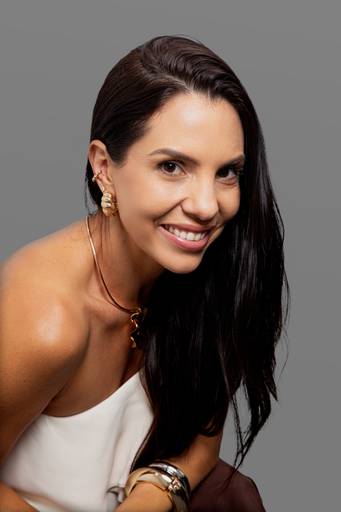 Profissional feminina em retrato, transmitindo seriedade e competência em ambiente corporativo com fundo discreto.