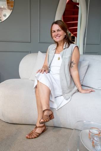 Retrato corporativo feminino em sofá de alto padrão com fundo elegante e um espelho