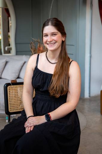 Retrato corporativo feminino em cadeira texturizada e com fundo elegante