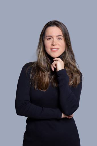 Retrato corporativo de mulher, com pose elegante e expressão de inteligência em fundo neutro.