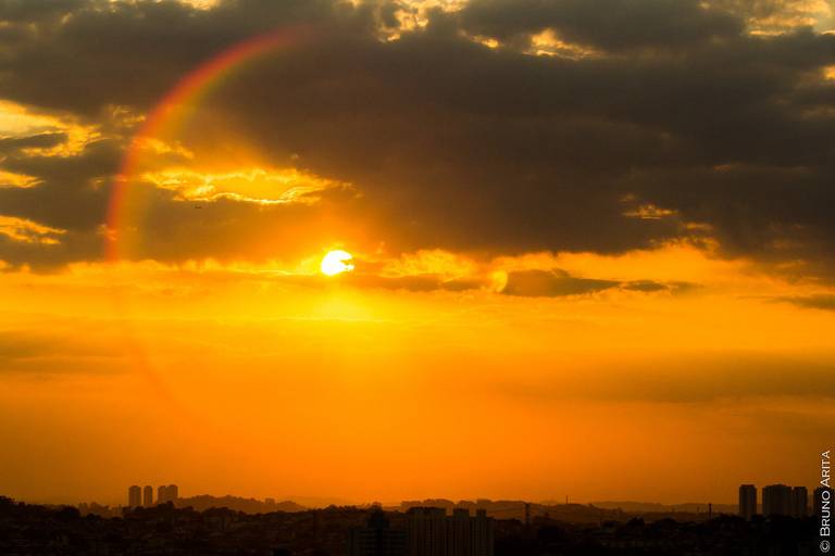 Pôr do sol em São Paulo, com o céu de outono em tons quentes e a silhueta da cidade no horizonte.