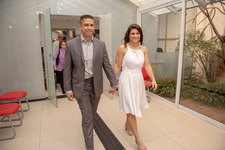 Casal entrando juntos para a cerimônia de casamento em um cartório, com expectativa.