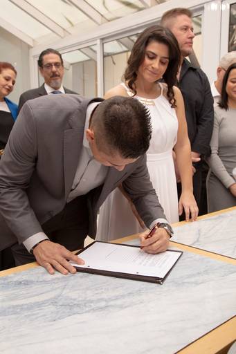 Noivo assinando o documento de casamento, formalizando o matrimônio civil.