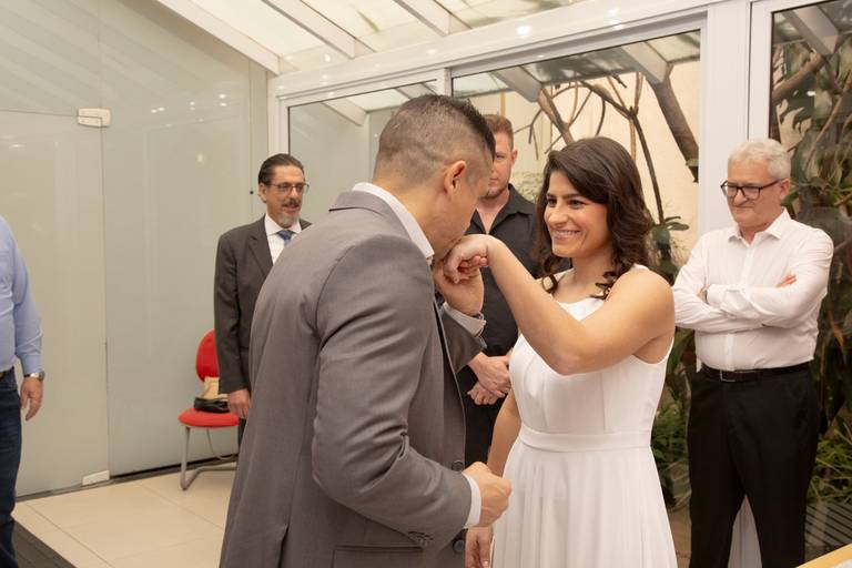 Noivo beijando a mão da noiva, em um gesto romântico durante a cerimônia de casamento.