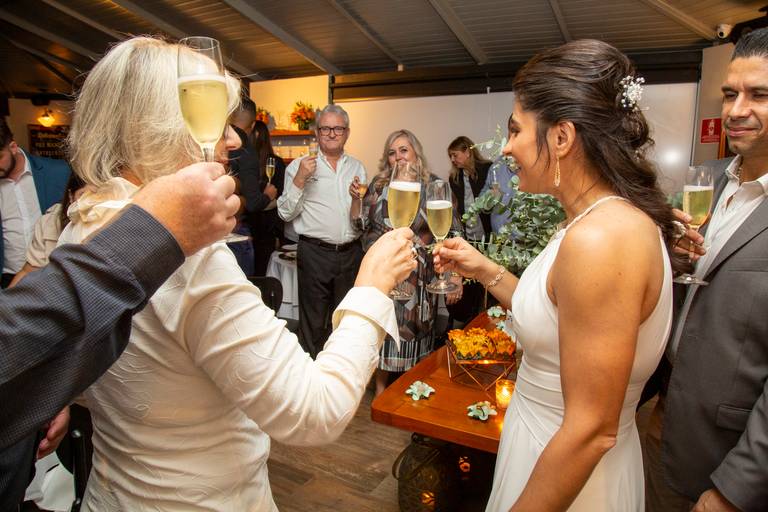 Noiva brindando com um convidado, compartilhando a alegria e a celebração do casamento.
