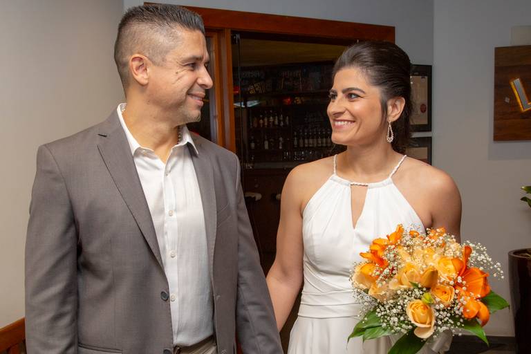Casal de noivos se olhando com carinho, em um momento romântico durante a festa de casamento.