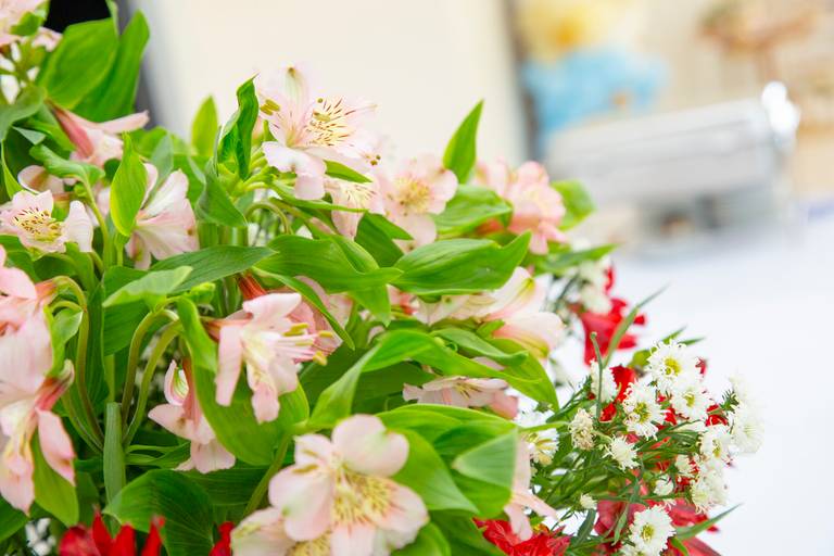 Detalhe de um arranjo de flores, com cores e texturas que embelezam o ambiente da festa.