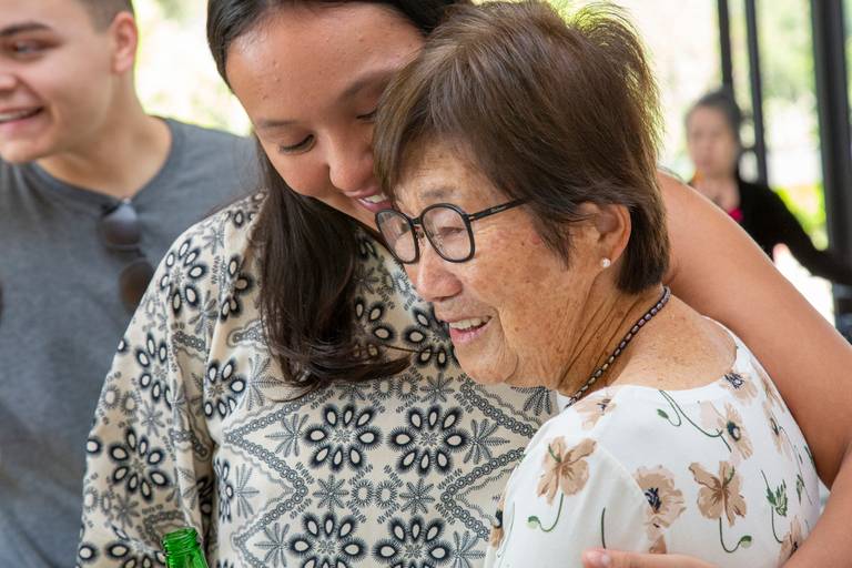 Aniversariante recebendo um abraço carinhoso, em um momento de afeto e comemoração.