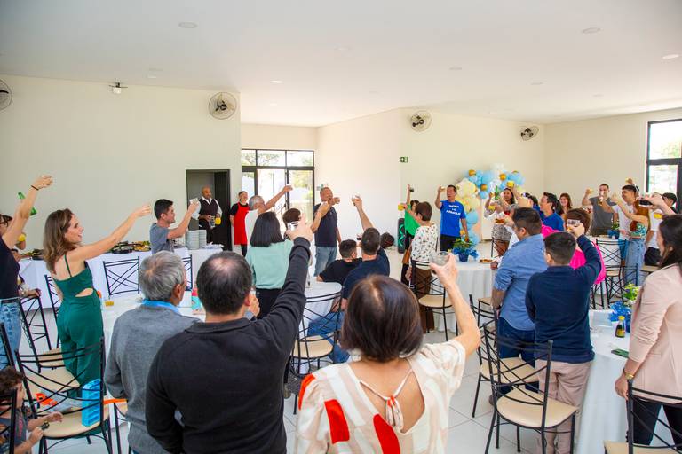 Convidados fazendo um brinde com suas taças, celebrando juntos em uma festividade.