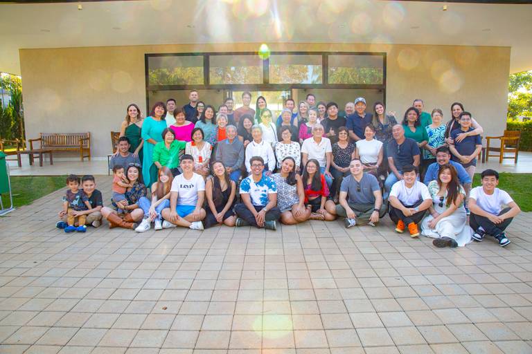 Foto de família reunida durante um aniversário, com todos celebrando o momento.