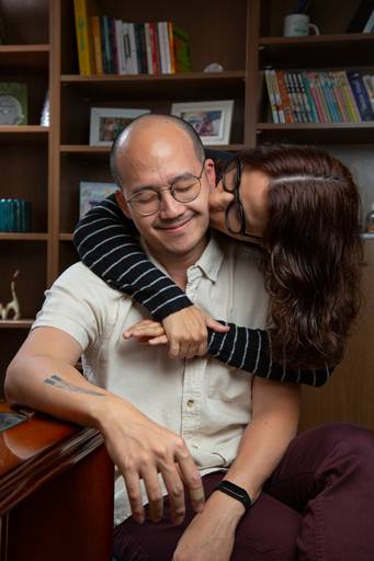 Casal em um momento carinhoso, trocando abraços ou olhares afetuosos durante o ensaio de família.