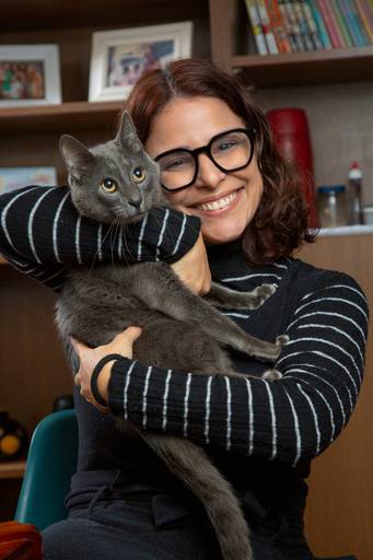 Mãe interagindo com o gatinho da família, em um momento de ternura e afeto.