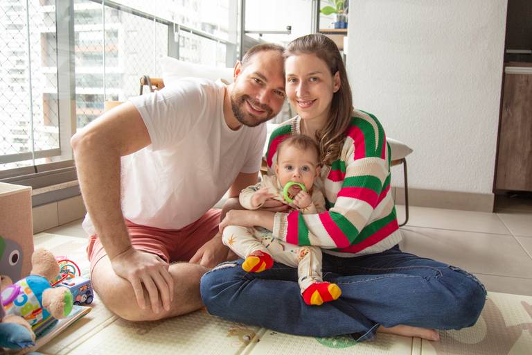 Família posando para uma foto, com todos juntos e felizes.