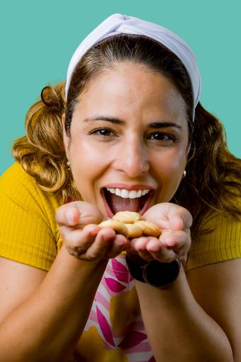 Close-up expressivo de confeiteira saboreando biscoitos artesanais, fotografia de branding focada na experiência sensorial e qualidade dos ingredientes.