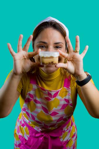 Fotografia de branding gastronômico com confeiteira segurando pote de doce artesanal em destaque, foco na textura do produto e expressão de satisfação.