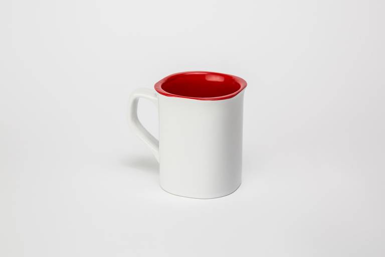 Fotografia still de caneca para personalização na cor branca na parte externa e vermelha na parte interna. Foto por Bruno Arita.