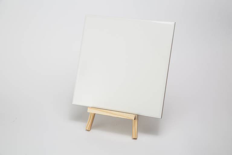 Fotografia still de azulejo para personalização na cor branca apoiado em cavalete. Foto por Bruno Arita.