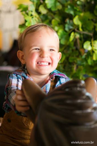 criança no cavalo de brinquedo sorrindo