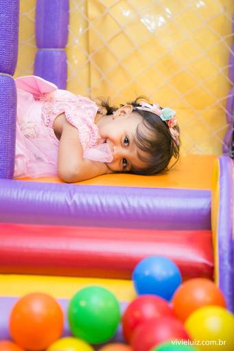 criança deitada e sorrindo no brinquedo inflavel