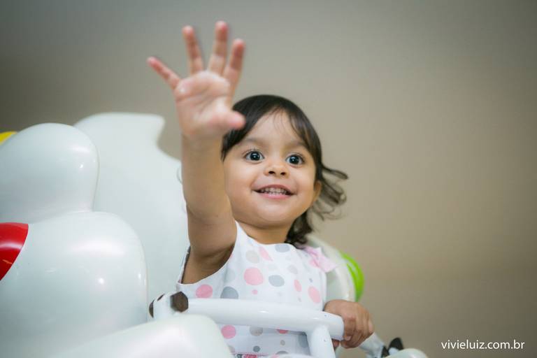 criança no brinquedo dando tchau