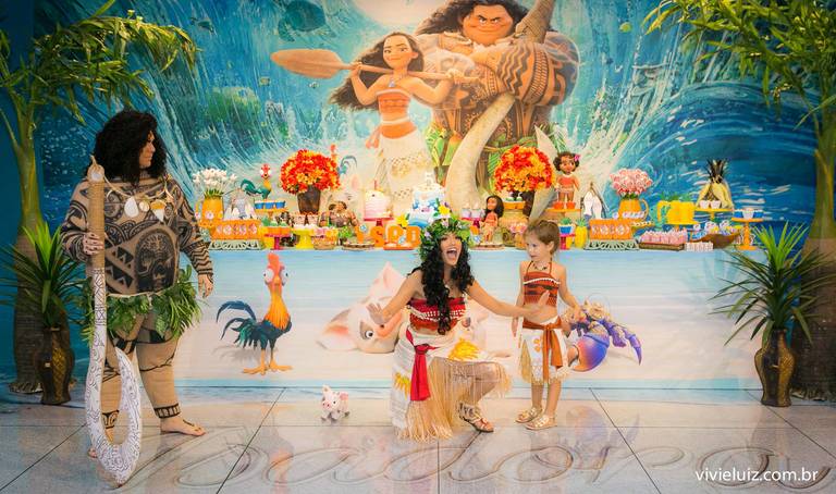 criança com o maui e moana na mesa do bolo