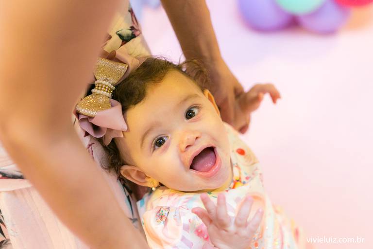 criança andando com ajuda da mae sorrindo