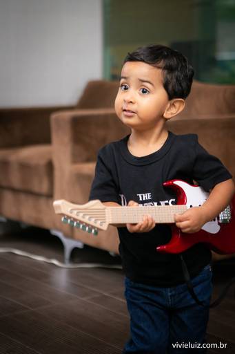 criança tocando guitarra