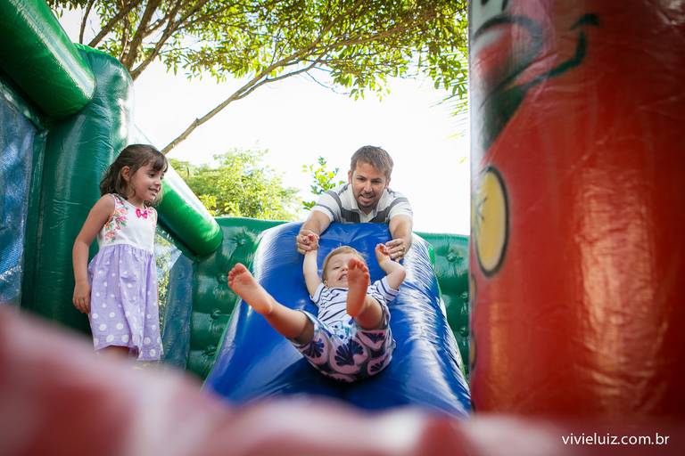 pai e filhos escorregando no inflavel