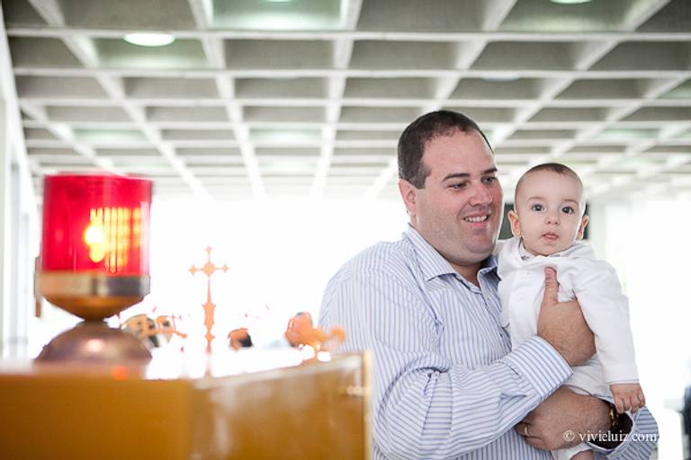 pai segurando filho no colo para o batsimo