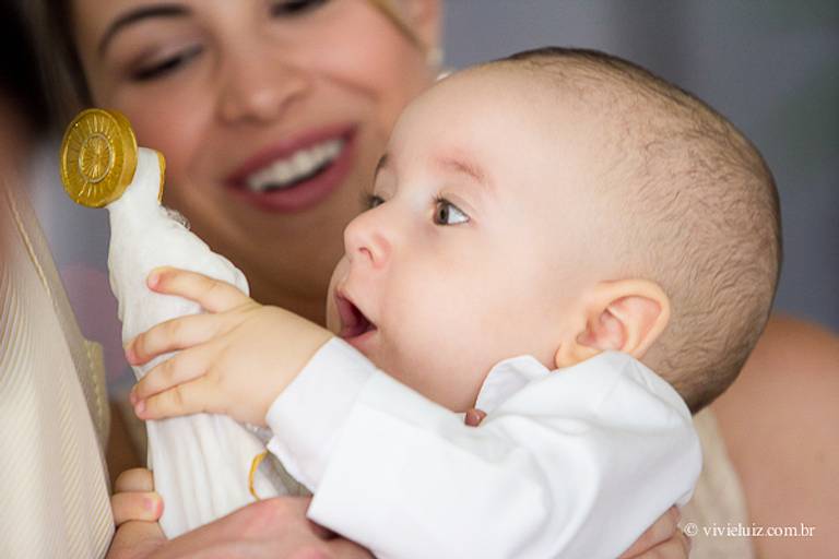 crianca pegando em nosso senhora no batizado