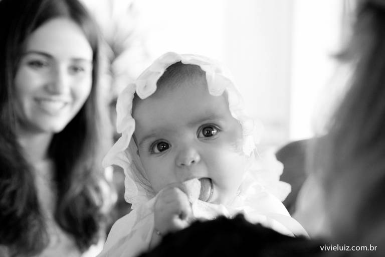 crianca com dedo na boca no batizado