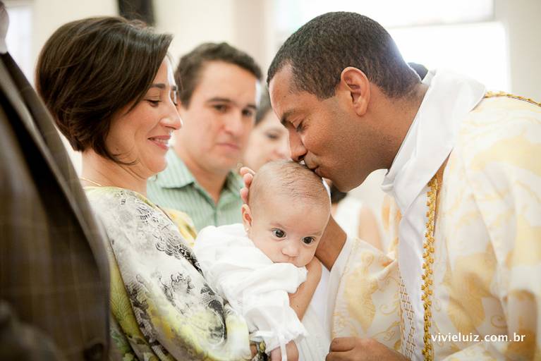 padre dando um beijo na bebê que foi batizado