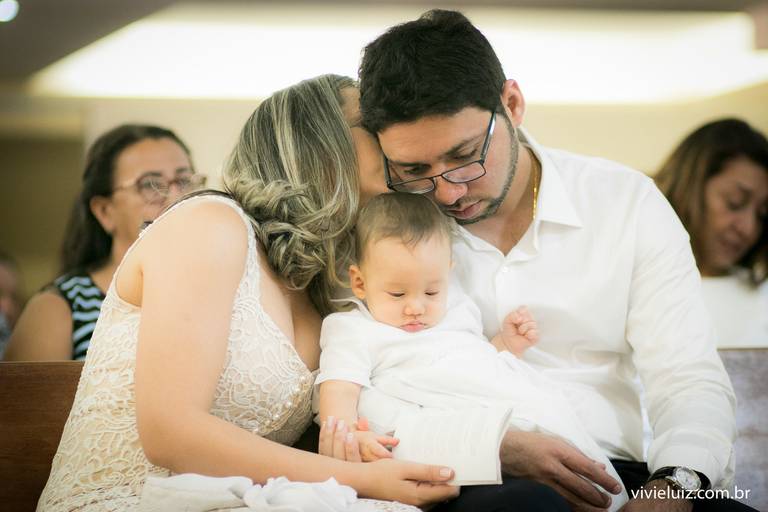 pai, mãe e filho na igreja para o batizado